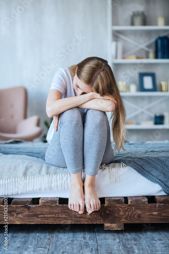 Fotografía Depression. Depressed young woman sitting holding her head down