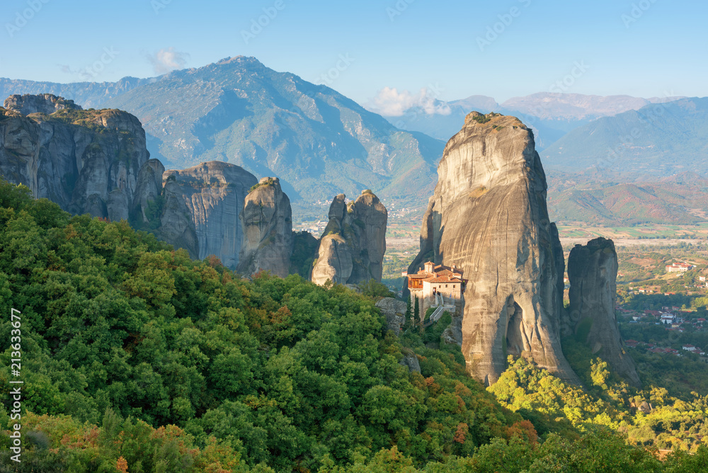 Beautiful scenic view, Orthodox Monastery of Rousanou (St. Barbara), immense monolithic pillar, green and yellow foliage at the background of stone wall in Meteora, Greece, Europe Beautiful scenic view, Orthodox Monastery of Rousanou (St. Barbara), immense monolithic pillar, green and yellow foliage at the background of stone wall in Meteora, Greece, Europe
