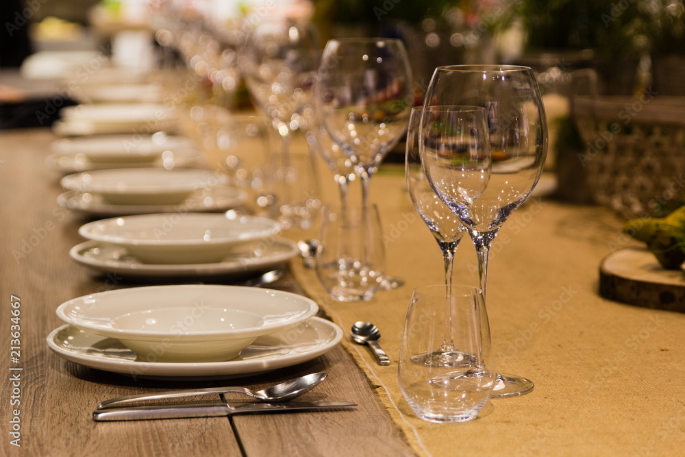 Fototapeta premium Empty wine glasses near the plates on the table