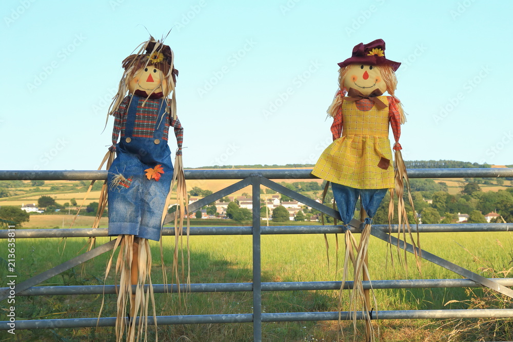 Cute straw filled boy and girl scarecrows on a farmland in East Devon