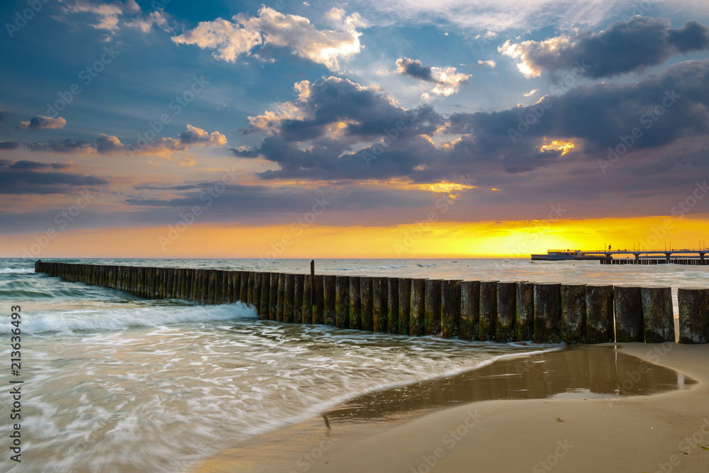 Sunset on the beach with breakwater, long time exposure