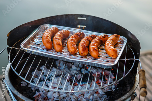 Grilled sausage on the flaming grill, close up photo