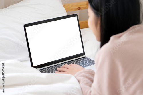 Woman using laptop computer with blank screen for mock up template background, technology and lifestyle, working at home background concept