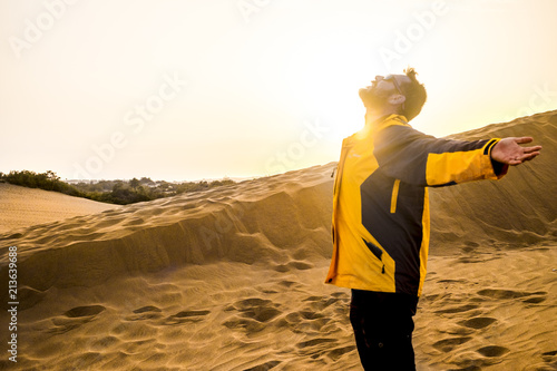 middle age man enjoying freedom and expolring leisure activity aopening arms and hugging the nature. desert arid place for alternative lifestyle and vacation time. summer and sunset with backlight.  photo
