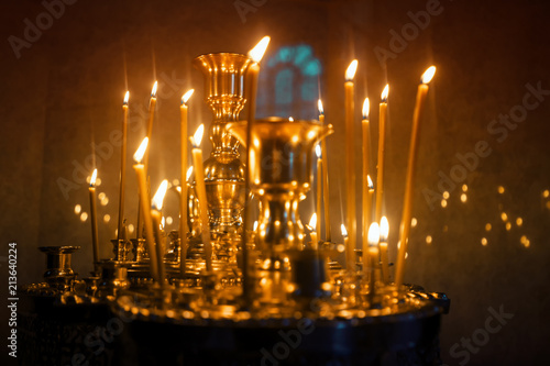 candles burn on the chandelier in the church