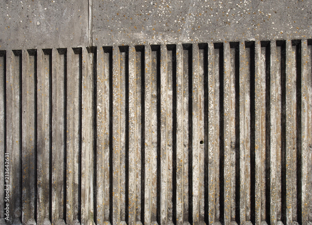 old exterior concrete wall with fluted vertical stripe design with a rough cast texture with shadow old exterior concrete wall with fluted vertical stripe design with a rough cast texture with shadow