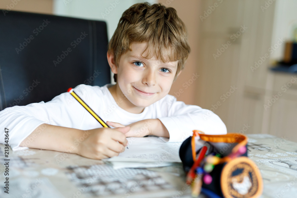 Tired kid boy at home making homework writing letters with colorful pens Tired kid boy at home making homework writing letters with colorful pens