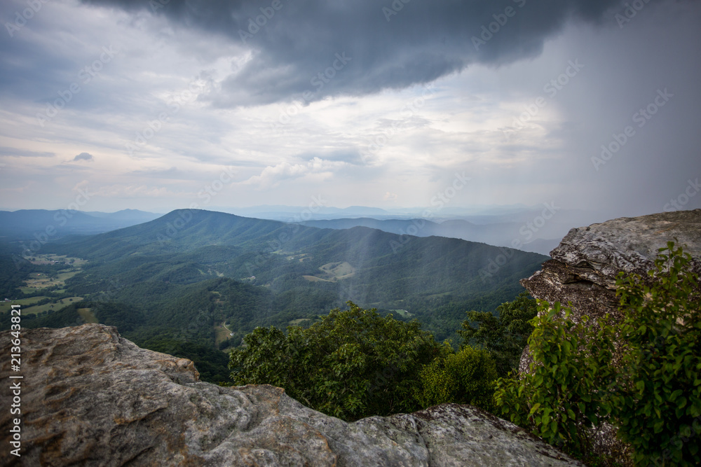Awesome Scenic view from McAfee Knob of Clouds and Sheets of Rain fall in Valley with mountains in the distance