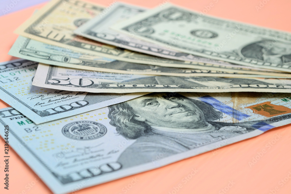 Banknotes of dollars of different value on a pink background Banknotes of dollars of different value on a pink background