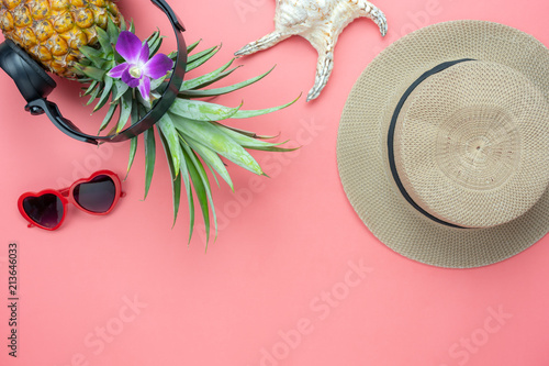 Table top view aerial image of food for summer holiday season & music background concept.Flat lay pineapple listening radio by black headphone for sign of seasonal with clothing on modern pink paper.