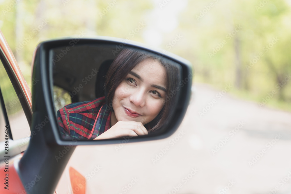 Portrait Beautiful young Asian girl  Smiling driver-woman is reflected in mirror of car.