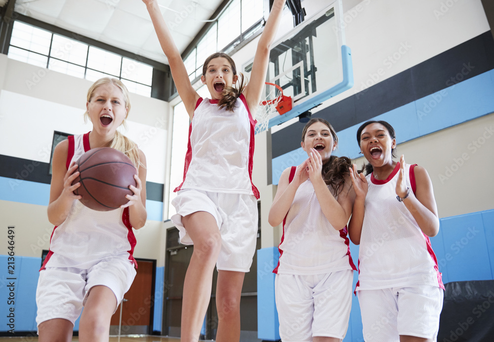 Naklejka premium Portrait Of Female High School Basketball Team Celebrating On Court