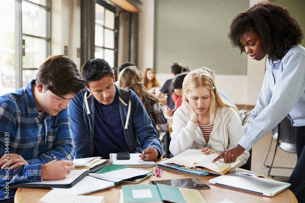 Group Of High School Students With Female Teacher Working At Desk Group Of High School Students With Female Teacher Working At Desk