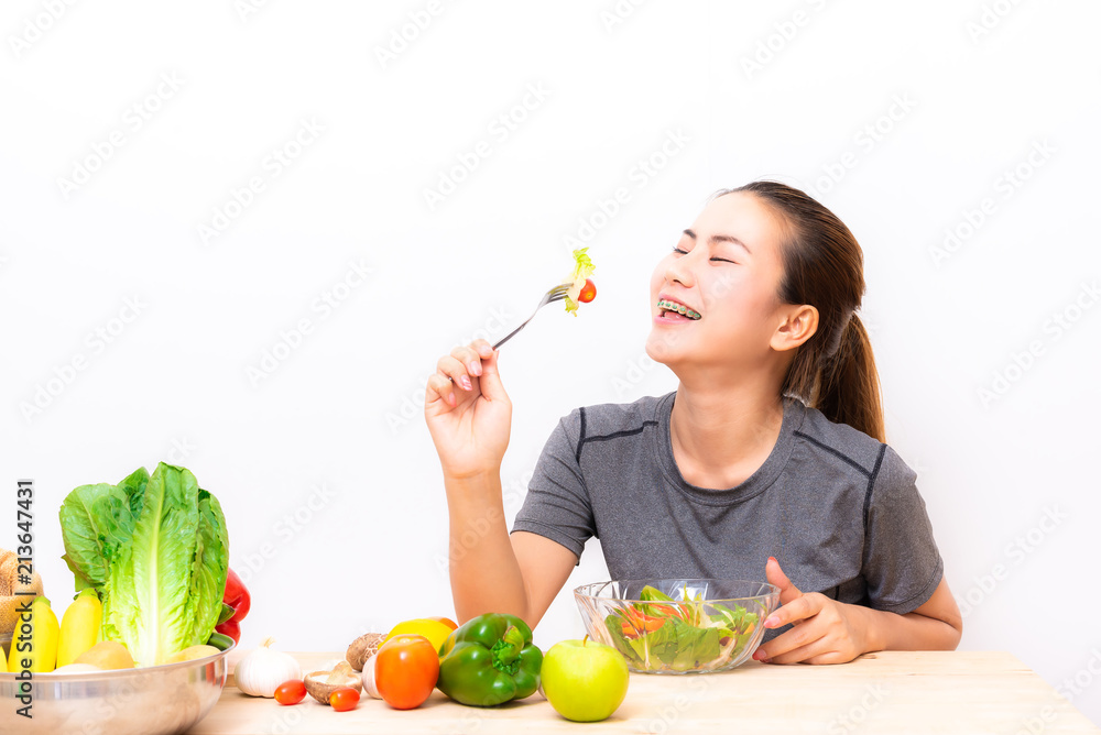Asian woman with dental brace enjoy eating salad vegetable