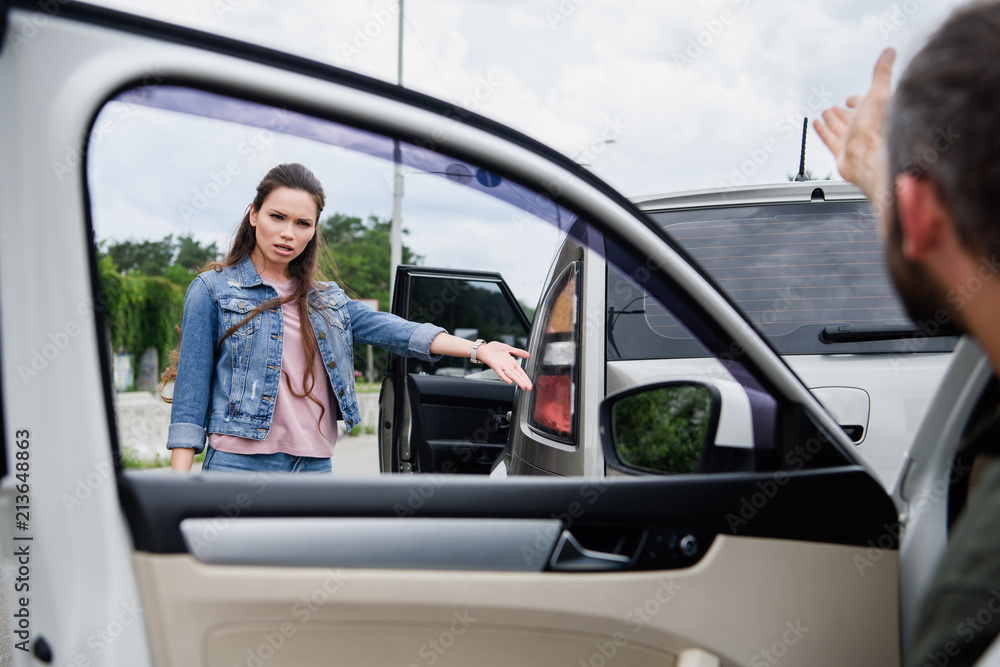 male and female drivers gesturing on road after car accident male and female drivers gesturing on road after car accident