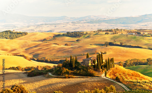 Italy. Pienza.  Beautiful Tuscany autumn rural landscape with cleaned fields and a farmhouse with cypress trees in the setting sun. Val d'Orcia natural Park photo