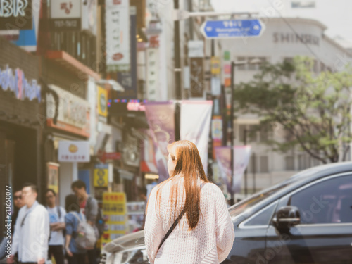 woman travel in city concept from back side of long hair asian woman wait across road with city background