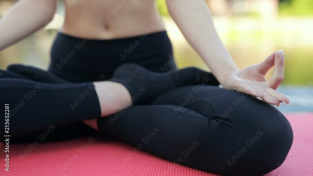 Woman sitting in the lotus posture. Hands with lotus sign are in the focus. Dolly shot. Woman sitting in the lotus posture. Hands with lotus sign are in the focus. Dolly shot.