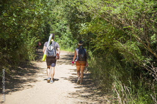 image of couple of tourists walking in the woods towards the beach