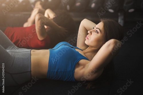 Sporty women doing abs workout in gym