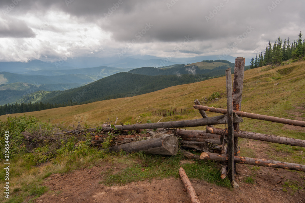 Old wooden fence in the Carpathians near the hills