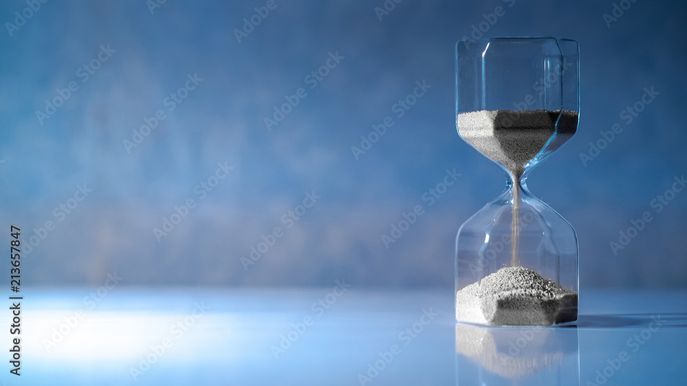 Sliver sand running through the shape of modern hourglass on white ...