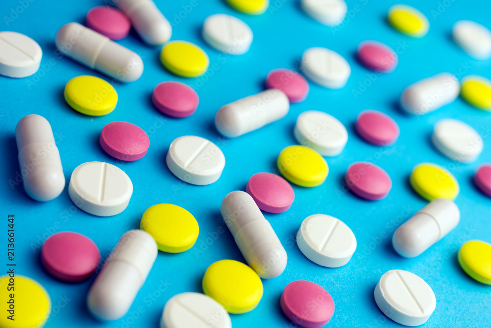 Pills tablets capsule drugs blue background. Medicine Pharmaceutical medicament concept.