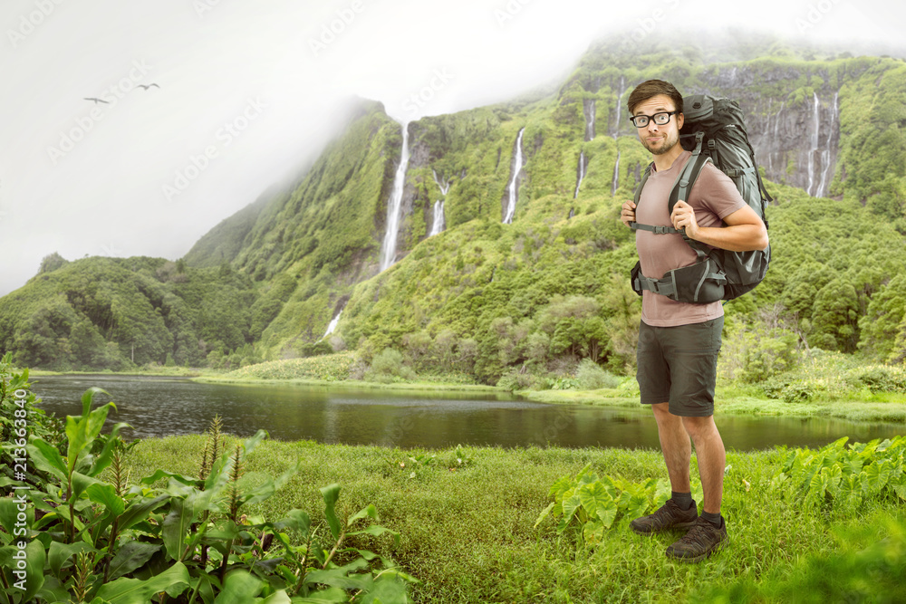 Naklejka premium Wanderer mit Rucksack vor tropischem Wasserfall