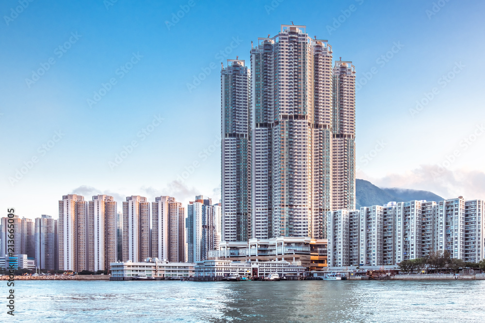 Fototapeta premium Hong Kong Island, Eastern Part. Residential area with business and government buildings. Sunset sky on background. Contrast between modern skyscrapers and Asia nature. View from Victoria Harbour.