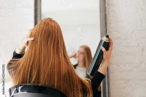 Girl taking care of her hair on hairdresser shop