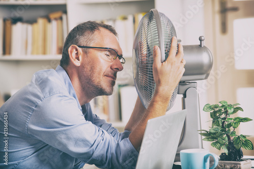 Fototapeta Man suffers from heat in the office or at home