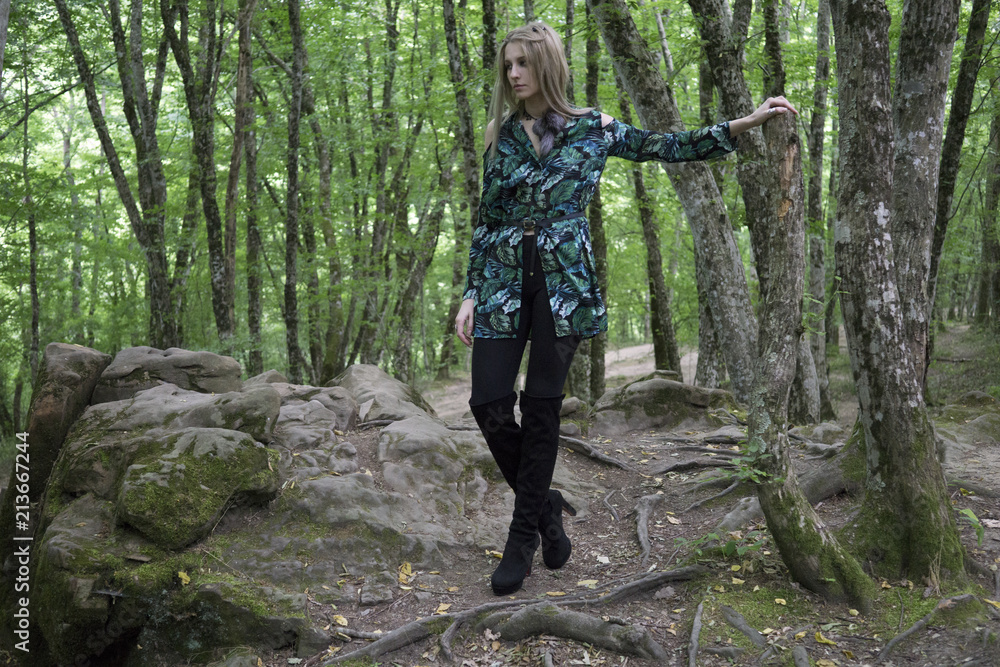 Fashion Model Girl on the Rock in the green summer forest Fashion Model Girl on the Rock in the green summer forest