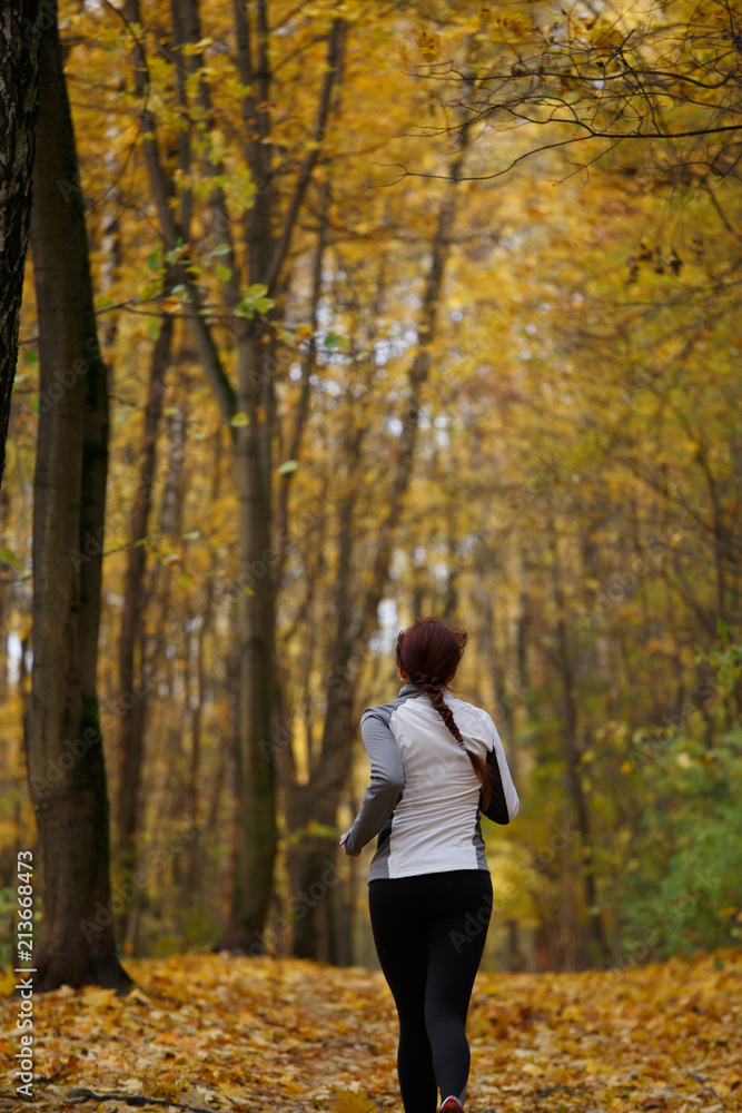 Photo from back in full growth of woman running forest Photo from back in full growth of woman running forest