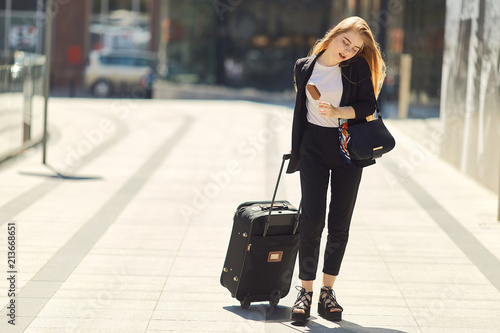 Blonde girl walking on the street with suitcase © Serhiy Hipskyy