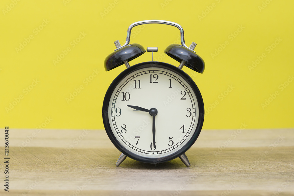 black bell clock on yellow background black bell clock on yellow background