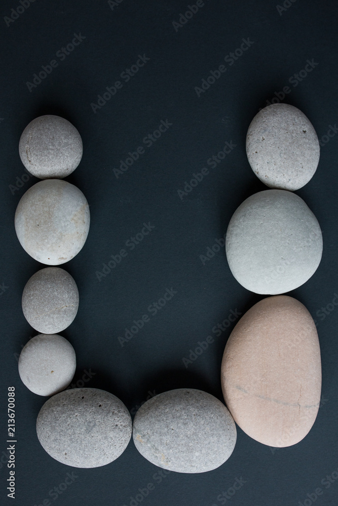 gray stones with white candle and grey background gray stones with white candle and grey background