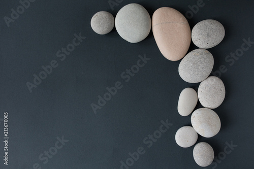 Canvas Print gray stones with white candle and grey background