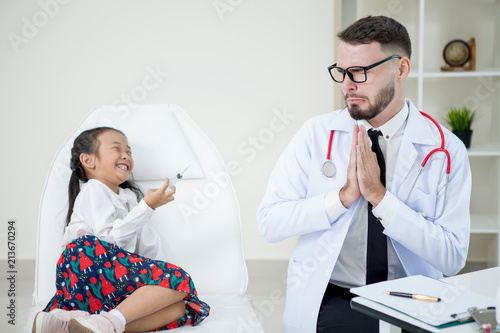 Fotografie girl holding a syringe needle with injection vaccination to doctor