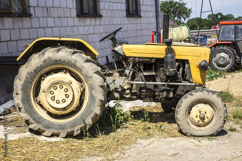 An old tractor produced in the 70s of the 20th century. Photo of the side of the agricultural machine. The necessary equipment for a dairy farm.