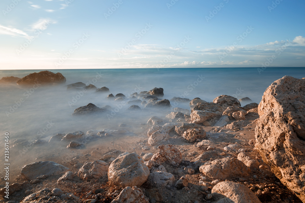 Water rocks and ocean at dusk. Long exposure of a rocky coastline 