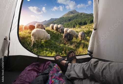 Two people lying in tent with a view of mountains.
