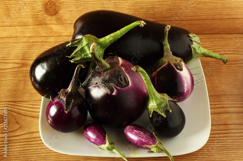 fresh eggplant or aubergine bringal varieties in wooden background photo