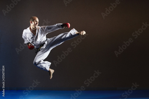 An athlete in karategi in a jump beats a kick to the side