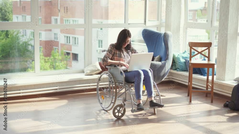Disabled woman in wheelchair with laptop Disabled woman in wheelchair with laptop