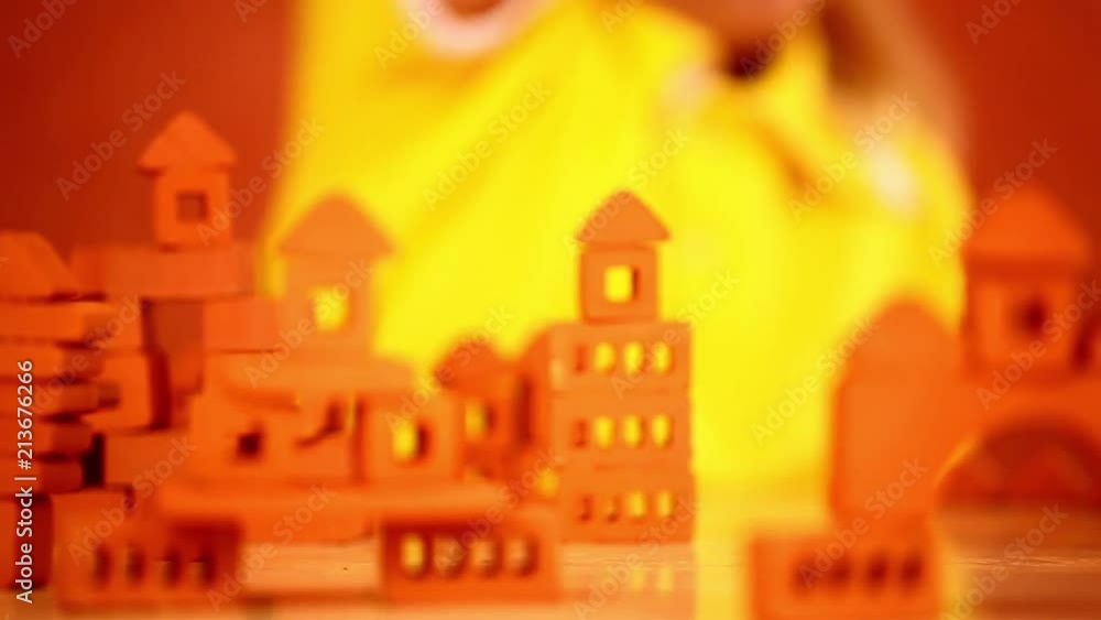 childhood, education, creation, art, architecture, building, people and children concept - a dreamy cute little girl wants to become an architect - she builds small houses and towns from small bricks childhood, education, creation, art, architecture, building, people and children concept - a dreamy cute little girl wants to become an architect - she builds small houses and towns from small bricks