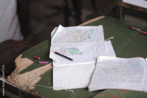 Obraz na płótnie african education - close up of a school kid sitting inside a classroom, holding a pencil, indoors on a sunny day w salonie