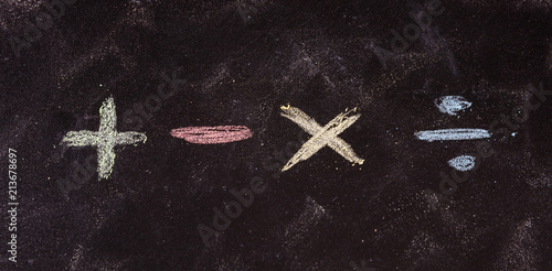 Mathematical symbols written with colorful chalks, isolated, on blackboard background.