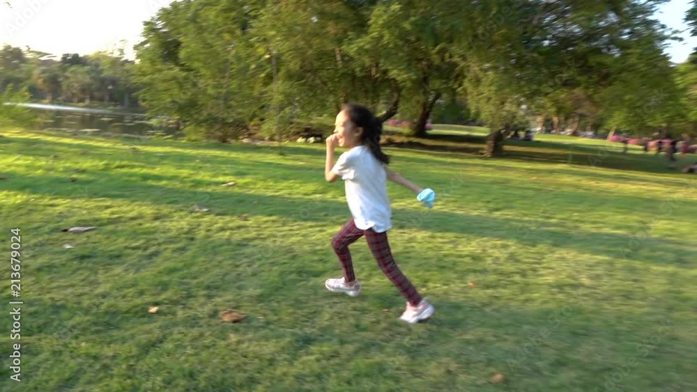 Slow Motion: Happiness asian little girl running in the park Slow Motion: Happiness asian little girl running in the park