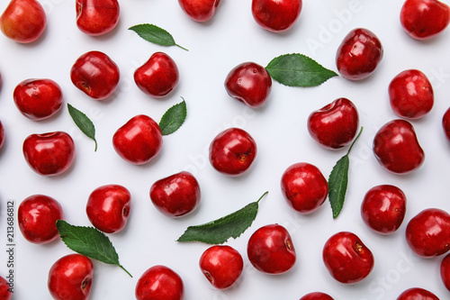 Sweet red cherries and leaves on white background