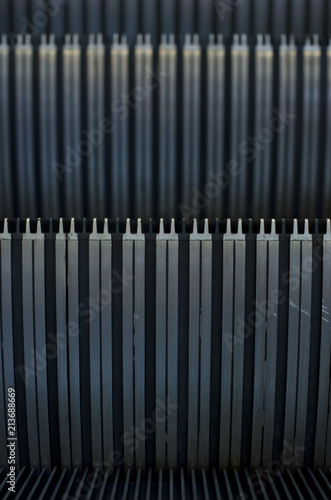 The dark texture steps on the escalator staircase in the mall. 